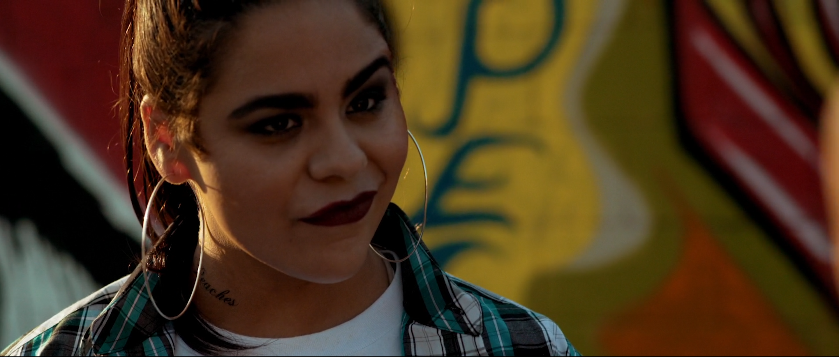Character in front of a custom graffiti mural painted on location for Avenge the Crows