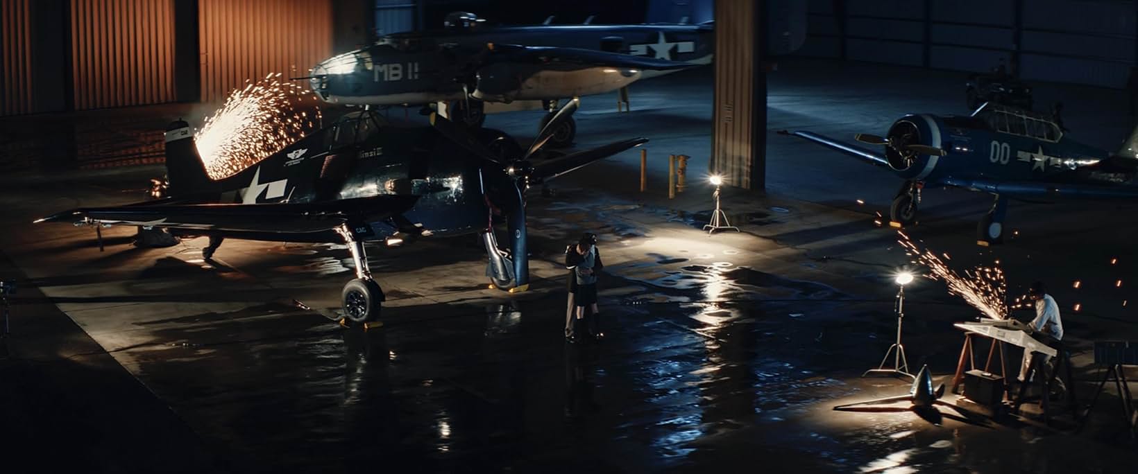 Full-scale helicopters dressed and painted on location for Edge of Space, lit by sparks in a dark hangar