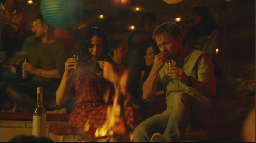 Night gathering around a fire with paper lanterns and string lights, In Other Words