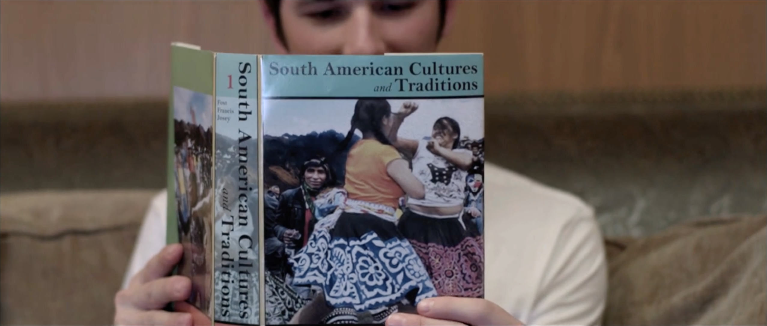 Character holding a book on South American cultures and traditions, Takanakuy