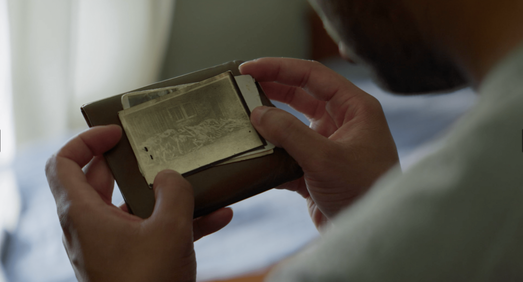 Hands holding an old photograph, The Liberator