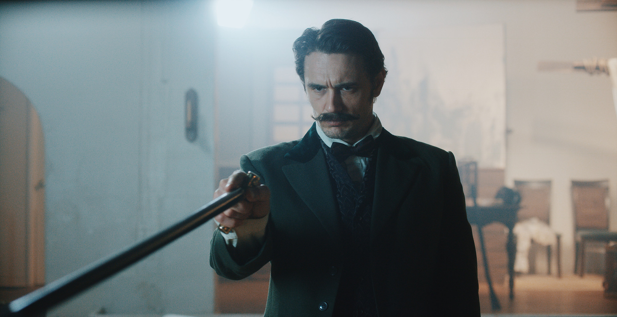Man in Victorian dress raising a long gun in a period interior from The Mad Whale