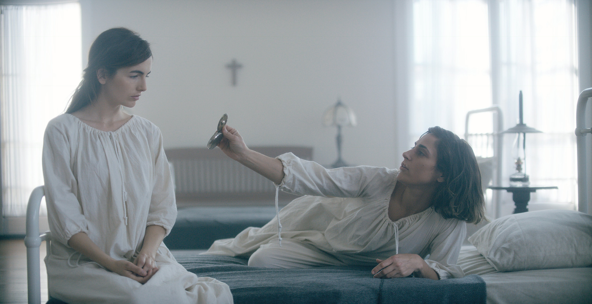 Two patients in white nightgowns on iron hospital beds in the asylum ward, The Mad Whale