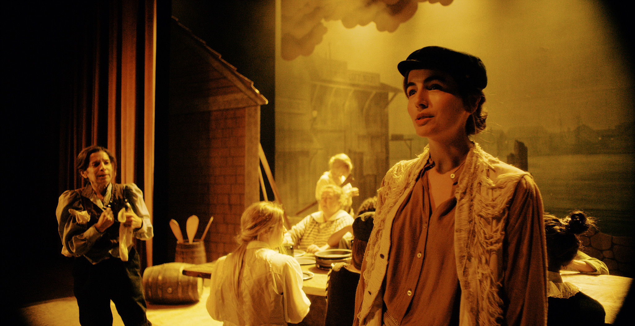 Candlelit period interior crowded with figures in Victorian dress, The Mad Whale