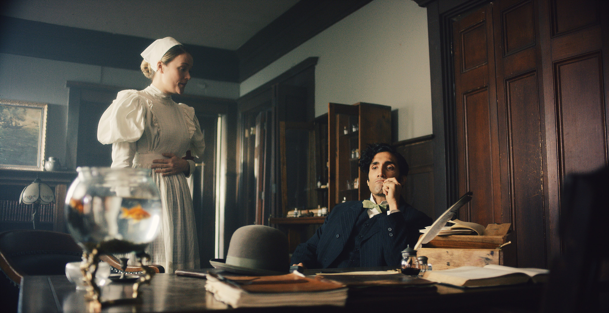 Asylum office in The Mad Whale, a nurse behind a desk with a glass specimen bowl and a man at a typewriter